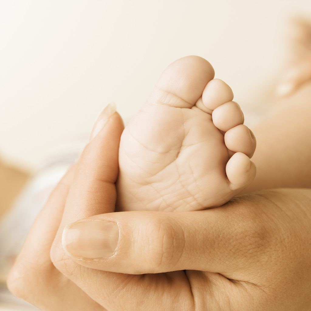 Close up of baby's foot in mother's hand